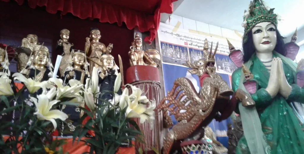 Hsaya U Win Hlaing’in altarında altın Burma Natları heykelleri ve Naga Ma yılan prensesi, Pyinsa Rupa heykeli yanında