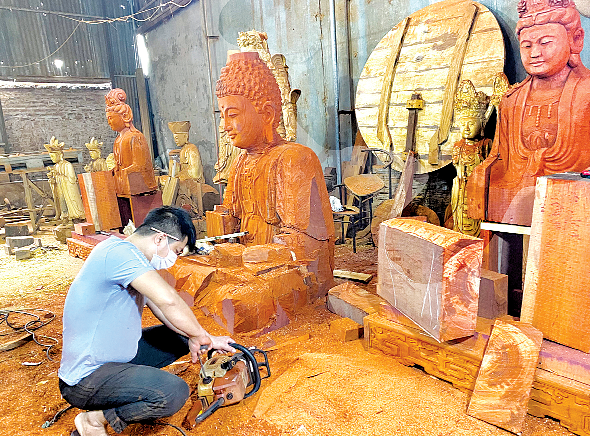Tahta bloktan Buda heykeli oyan Taylandlı bir zanaatkâr – Buda heykellerinin yapıldığı ülkelerden Tayland